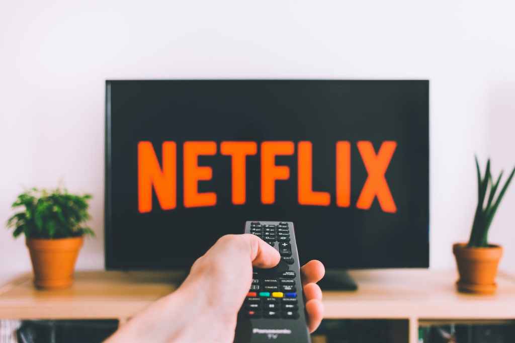 hand pointing remote control at a TV with Netflix on the screen