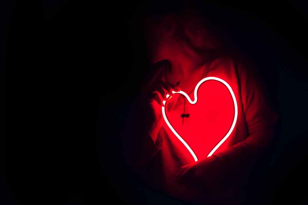 black background with a red neon heart in the bottom right corner